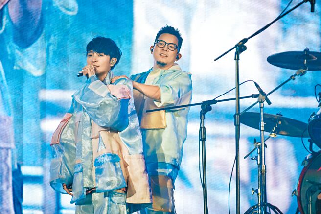 青峰（左）昨在台上唱到落枕，小威帮他按摩肩膀。（环球音乐提供）