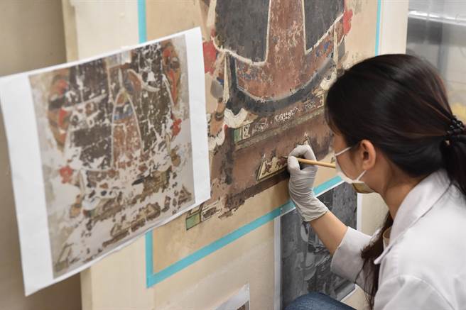 台湾师范大学文保中心博士生正在修復画作。(台师大提供)