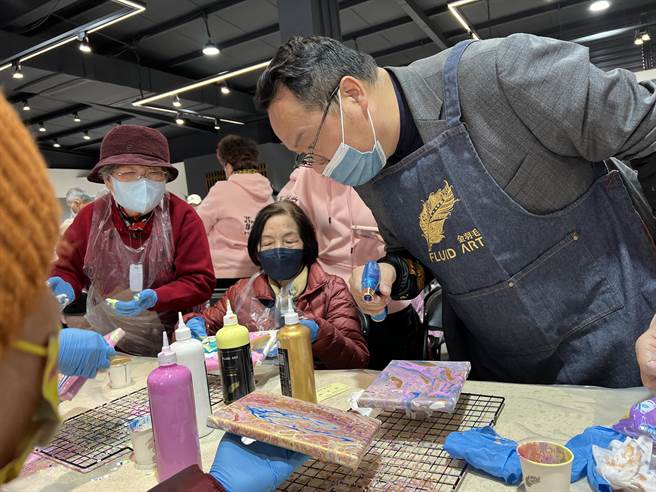 东辰公司董事长萧毓中出钱、出场地让100位银髮长辈动手体验流体彩绘。（蔡依珍摄）