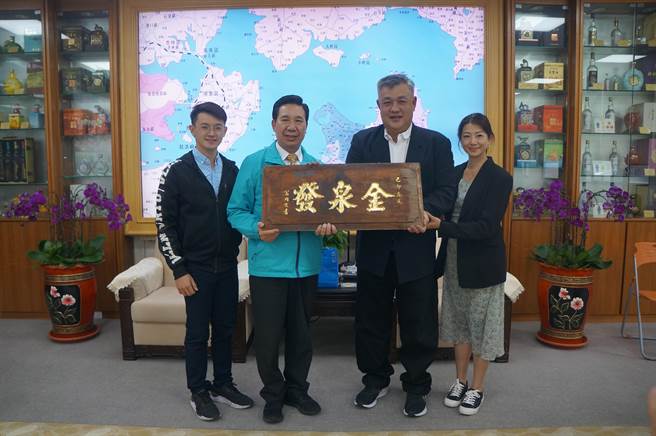 马来西亚华侨吴友铿(右二)带着妻儿返金祭祖，特别带了祖父「金泉发」商号的复刻版送给县长陈福海(左二)。(图／金门县政府提供)