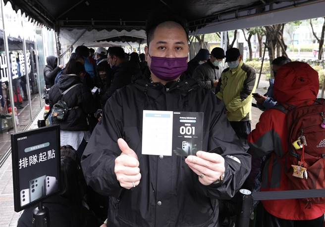 来自新庄的许先生15日凌晨就来等候取机，迫不及待分享使用心得。（陈俊吉摄）