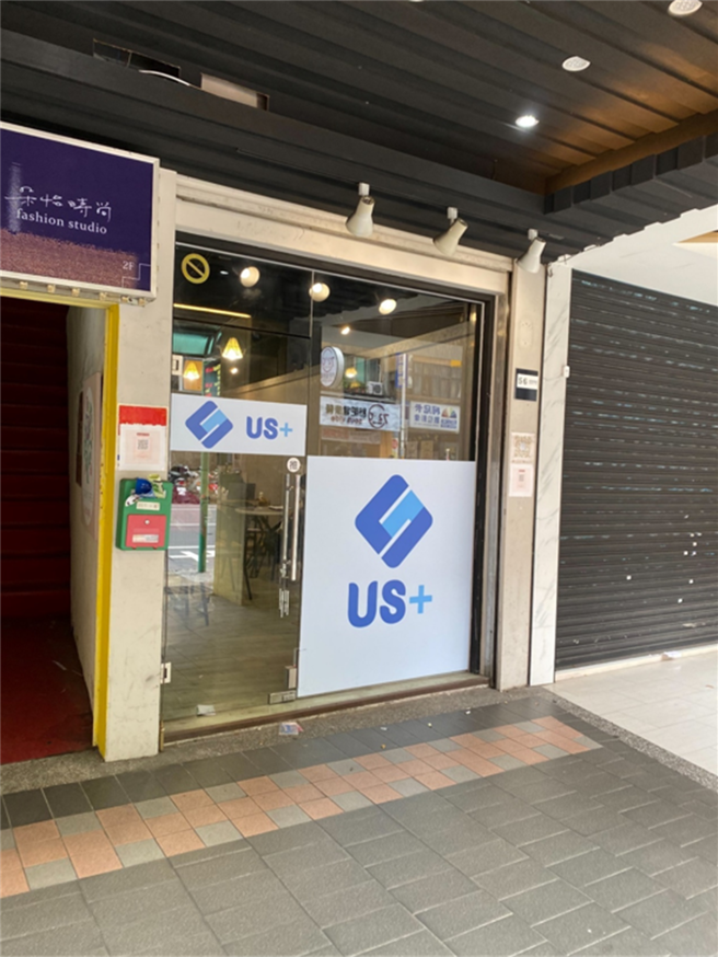 实体店面大片玻璃落地窗上显目印有「US＋」字样，外观看进去空间狭小，内部设备简陋。（警方提供）