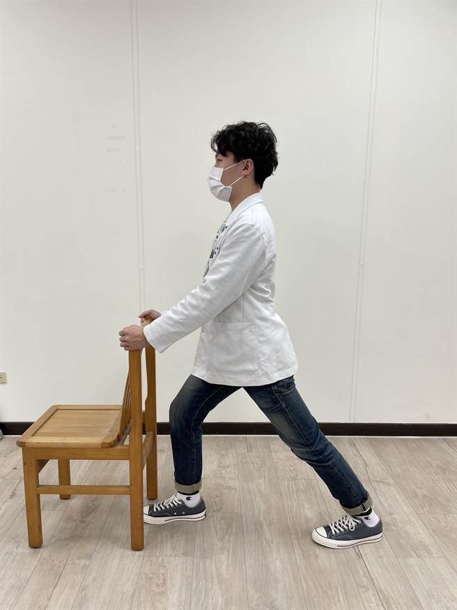 双手扶住固定物，使用弓箭步，进行后侧脚小腿。（卫福部苗栗医院提供／李京升苗栗传真）