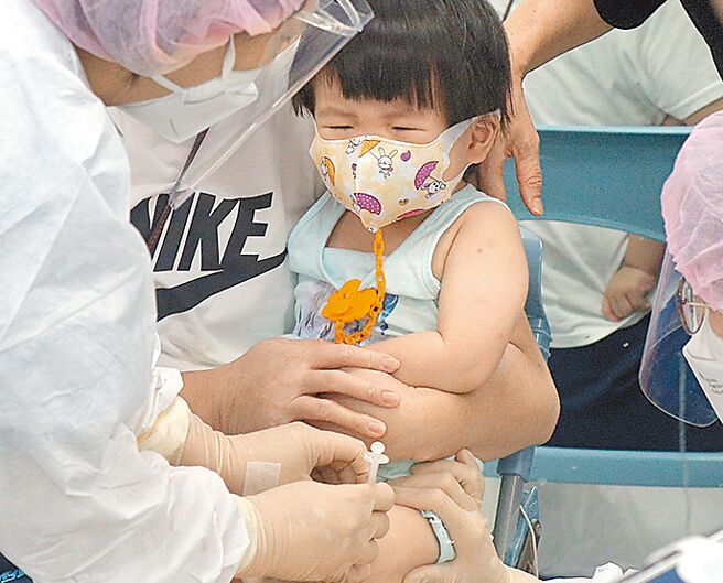 圖為家長帶著小朋友前往接種疫苗。（本報資料照片）