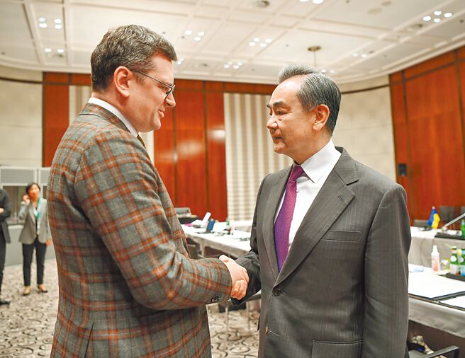 中共中央外事工作委員會辦公室主任王毅（右）20日訪俄前，在德國與烏克蘭外長庫列巴會面。（新華社）