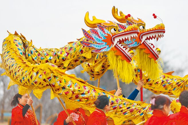 大陆智库预计今年经济增长率可达7%，随着生活復常，大陆民间活动热络。图为江苏南京的老妈妈舞龙队在长江岸边舞龙。当日是农历二月初二，民间有「二月二，龙抬头」的俗语。（中新社）