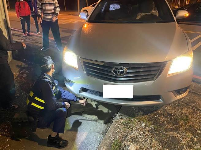 55岁陈姓男子右前轮悬空卡路边，机智雾峰警就地取材助车轮顺利脱困。（雾峰警分局提供／潘虹恩台中传真）