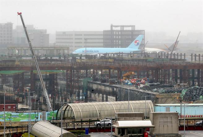 机场公司表示第三航厦建设进度已达45.12％，完工后桃机将成为东亚航空枢纽。1架大韩航空A380型客机滑行时经过第三航厦工地。（范扬光摄）