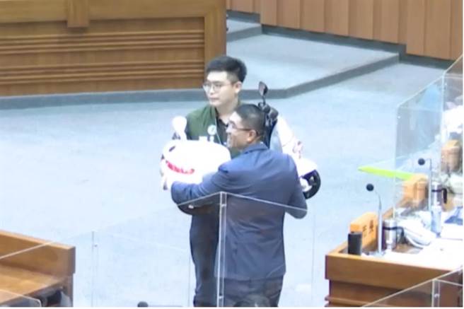 民进党议员张颢瀚汉质询结束送了一台「迷你Gogoro」，希望电动机车政见不要缩水，让现场氛围轻松起来。（徐佑升摄）