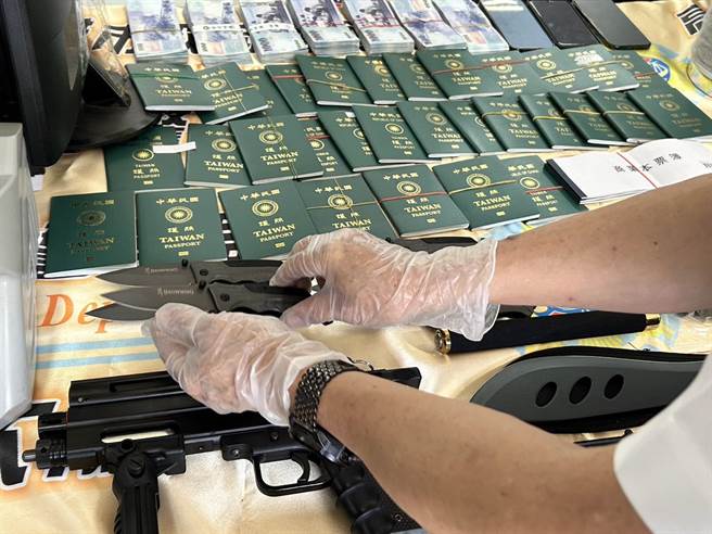 警方查獲41本護照、客戶資料、摺疊刀、手指虎、鎮暴槍等證物。（崔正綱攝）