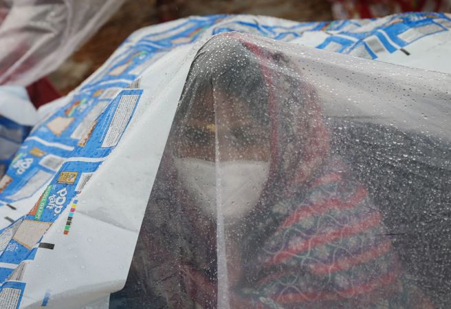 印度新冠肺炎疫情一度严峻，重症死亡高峰期间百姓心生恐惧，居民外出会配戴口罩，还有人自行「加码」套上塑胶布求心安。（资料照／路透社）