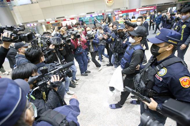 学甲枪击案主谋洪政军（右二）及枪手孔祥志返台，两人入境后由台南市警局霹雳小组干员押回台南。（范扬光摄）