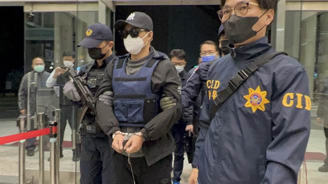 警方将枪手孔祥志（右二）上手铐、脚镣，带回台南侦讯。（张毓翎摄）