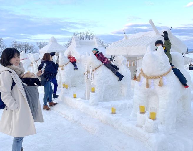 「犬子雪祭」打造出多座超萌的巨犬雪雕，吸引许多人携家带眷来参与。（何书青摄）