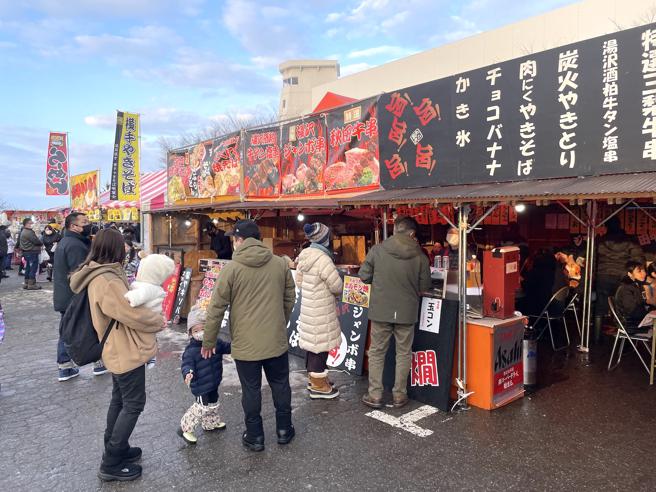 美食摊贩匯集会场旁的街上，让民眾打打牙祭。（何书青摄）