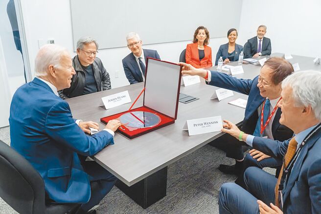 台积电去年12月7日在美国亚利桑那州凤凰城的晶片厂扩大投资，美国总统拜登亲自出席装机典礼。图为台积电董事长刘德音（右二）送给拜登（左）一张晶圆礼物。（摘自美国总统拜登脸书）