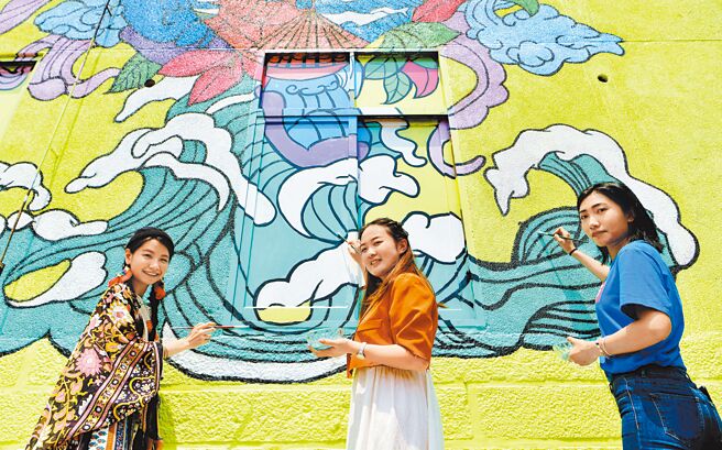 今年大陸的對台工作基調將聚焦「四要」，包括「要和平、要發展、要交流、要合作」，陸方將更凸顯軟性促融的一面。圖為福州大學廈門工藝美術學院的鄭曼璐（中）和劉淼（右）與新竹清華大學美術學院研究生張雅嵐（左）共同創作塗鴉作品《源園》。（新華社資料照片）