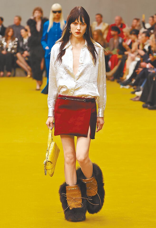 带金属光泽的衬衫、搭配红色迷你裙、毛毛雪靴，撞色搭配黄色的包款，呈现復古奢华的气息。（GUCCI提供）