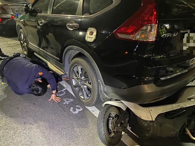 機車擦撞後滑行一旁，插進路邊休旅車底，員警利用千斤頂順利將機車拉出。（翻攝照片／崔正綱高雄傳真）