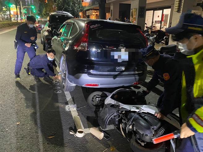 機車擦撞後滑行一旁，插進路邊休旅車底，員警利用千斤頂順利將機車拉出。（翻攝照片／崔正綱高雄傳真）