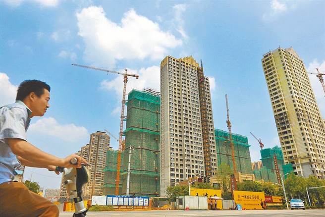 中指研究院报告指出，大陆2月楼市成交量月增逾三成。图为南京市民骑车经过一处在建楼盘。（图／中新社资料照）