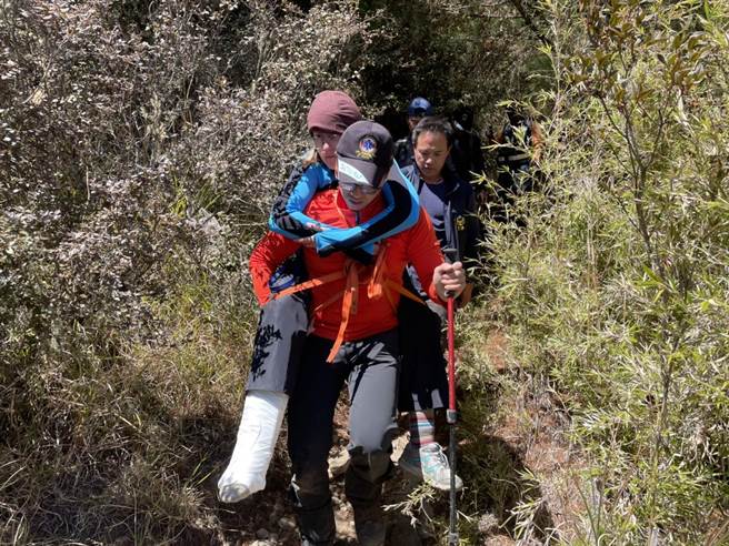 美籍女性登山客脚踝受伤无法行走，消防弟兄等背负下山，运至池有山登山口后，由梨山92送往梨山卫生所救治。（台中市消防局提供）