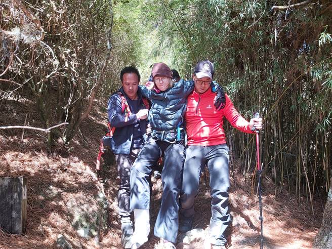 美籍女性登山客脚踝受伤无法行走，消防弟兄等背负下山，运至池有山登山口后，由梨山92送往梨山卫生所救治。（台中市消防局提供）