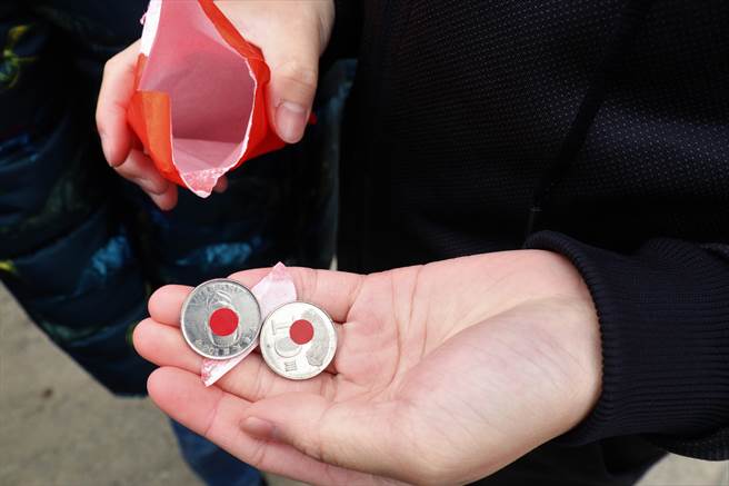 许多人带着纸箱、雨伞、袋子「接吉」，最后抢到红包发现里面有2个10元硬币，也十分开心说好事成双、讨个吉利。（张茂雄摄）