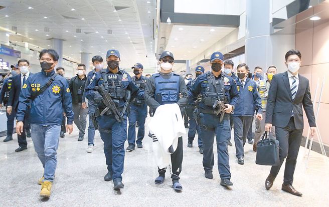 去年犯下台南學甲槍擊案主謀洪政軍（中）及槍手孔祥志25日回台，兩人入境後由台南市警局大陣仗押回台南。（資料照片/范揚光攝）
