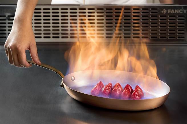 春季新菜「火焰糖渍草莓奶酪干邑橙酒酱」，连甜点也在铁板上演绎。（乐葵法式铁板烧提供）