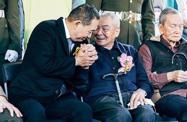 新北市長侯友宜(左)28日前往三重228公園出席二二八和平紀念日76周年紀念儀式，向二二八受難者趙水濱（右）慰問並握手致意。（郭吉銓攝）