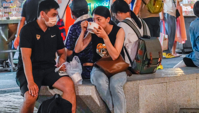 民眾到宜兰某葱油饼店消费，结帐的时候发生纠纷。图为民眾吃路边摊的画面。（示意图／本报系资料照）