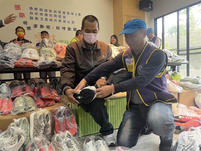 云林家扶家长在同济会总召卢忆顺协助下试穿鞋子。（周丽兰摄）