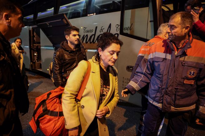 在对撞事故幸运生还的列车乘客，由巴士接抵第撒隆尼基车站。（图／路透社）