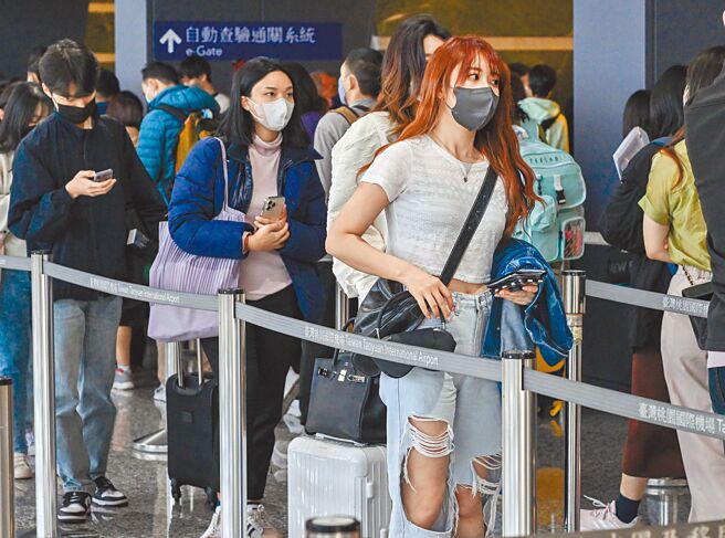 國內本土新冠確診新增1萬1995例，較上周三下降25.7％。指揮中心表示，輕症確診者免隔離政策，最快3月底上路。圖為桃園機場3月起不再提供免費快篩，入境旅客排隊通關。（本報資料照片）