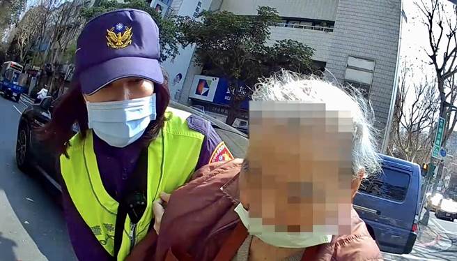 照片1-臺北市保安警察大隊員警協助攙扶陷於車陣進退不得老翁，順利通過馬路。（翻攝照片／林郁平台北傳真）