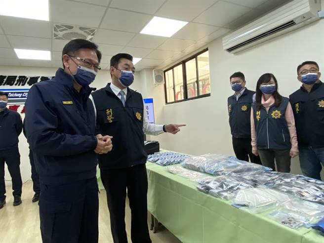 台中市政府警察局刑大3日舉行掃黑打詐緝毒記者會，副局長鄧學鑫（左）檢視同仁查扣的贓證物。（張妍溱攝）