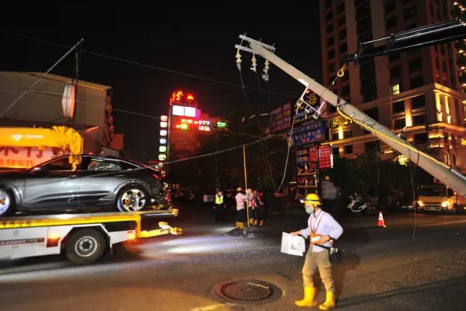 奧迪車主請拖吊業者將車子拖回原廠時，拖吊車才剛駛離約30公尺，就因為吊臂未收，導致勾到一旁電線，將電線桿扯斷，電桿還剛好砸在奧迪車上。（翻攝照片）