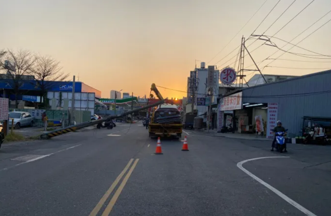 奧迪車主請拖吊業者將車子拖回原廠時，拖吊車才剛駛離約30公尺，就因為吊臂未收，導致勾到一旁電線，將電線桿扯斷，電桿還剛好砸在奧迪車上。（翻攝照片）