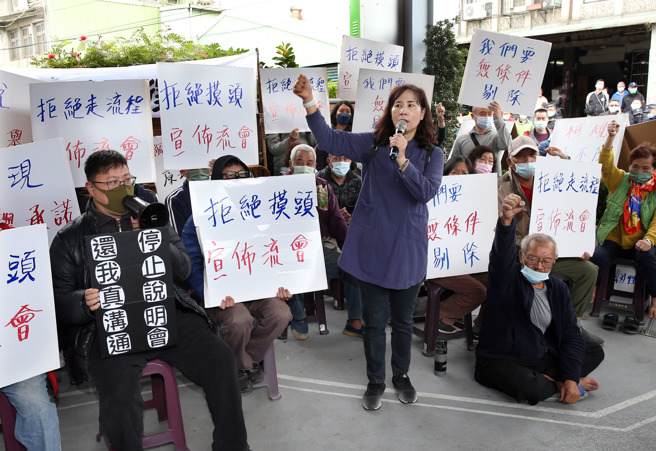 台北市地政局4日在社子岛举行剔除徵收说明会，社子岛自救会成员在会场外手持标语杯葛抗议，要求市长蒋万安落实竞选承诺，撤回柯市府方案，先辅导修缮并重新研拟聚落保留范围。（姚志平摄）