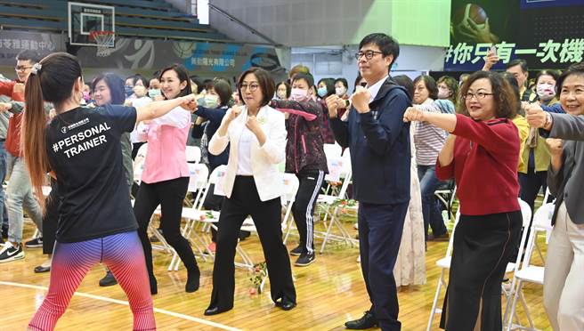 高雄市长陈其迈（前右三）、议长康裕成（前右四）4 日参加妇女节活动，跟随老师的指导做运动。（林瑞益摄）