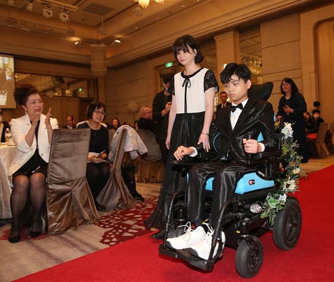 台北芙蓉扶轮社与卓蓉制服5日举行「眺望美好慈善公益走秀」活动，立志拍片成为一名有百万订阅的网红的伟翔(右)与母亲穿上专属秀服走伸展台。(陈怡诚摄)