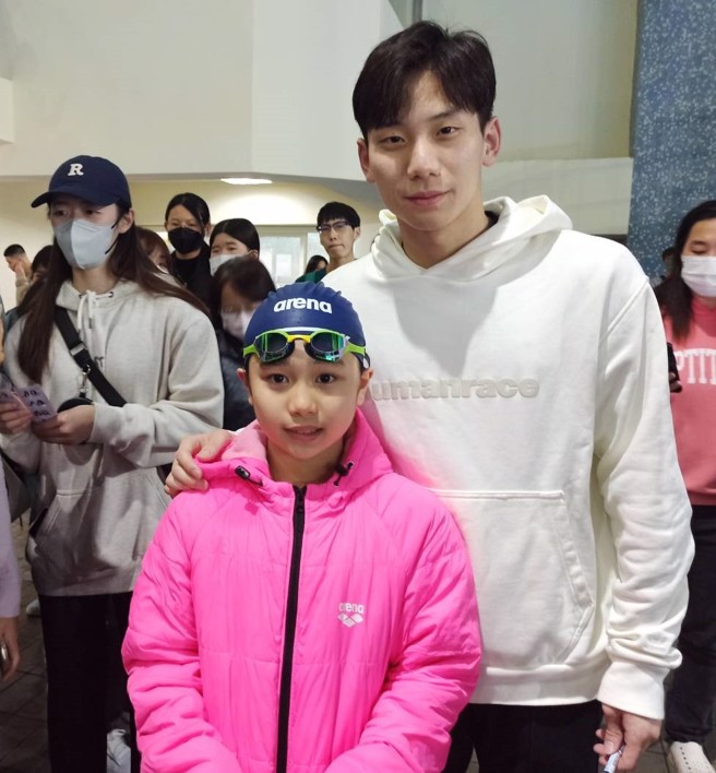 王冠闳（右）鼓励宝岛游泳小神童何康婗（左）。（全国游泳协会提供）