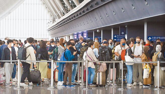 疫情趋缓桃机人潮涌现，桃园机场南跑道4日下午疑遭无人机闯入导致机场关闭23分钟，共影响航班14架次及旅客1737人。图为桃园机场第一航厦入境管制区内，大批旅客正在排队通关入境。（范扬光摄）