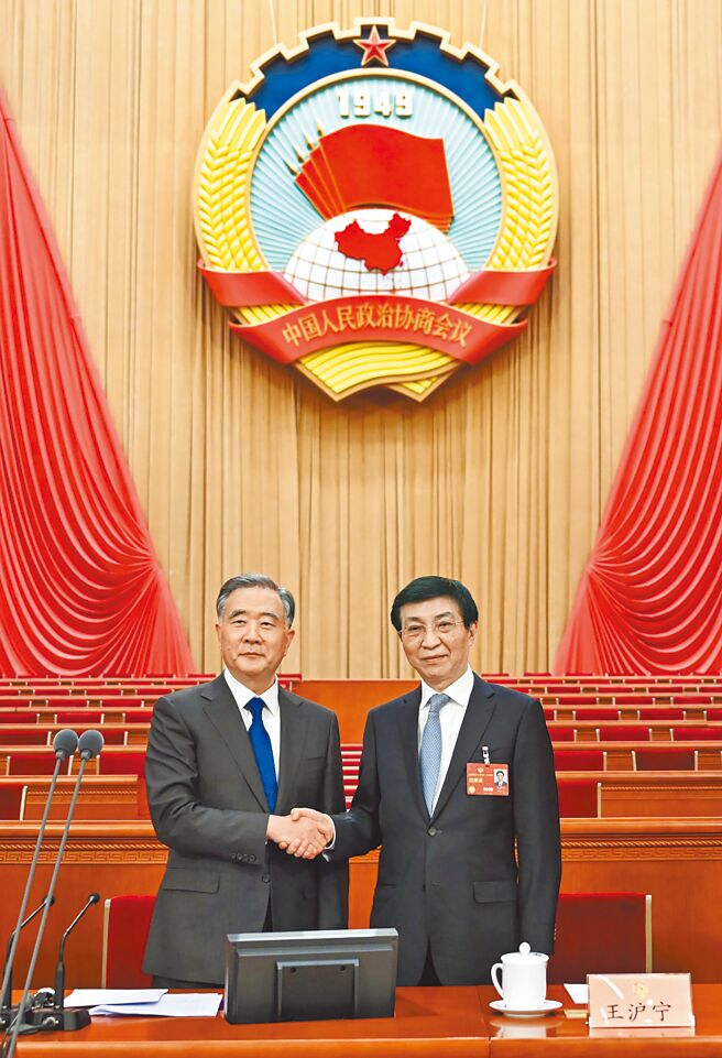 大陆全国两会开幕，适逢换届年，新旧任全国政协主席王沪寧（右）、汪洋（左）握手，象徵交接。（新华社）