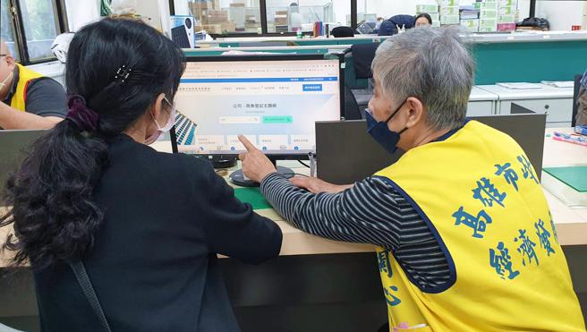志工协助民眾使用公司、商业登记主题网搜寻资讯，申办登记更便利。(高市经发局提供)