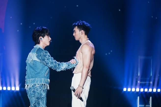 邱锋泽（左）与黄伟晋对唱时，搞笑摸他胸肌。（滚石唱片提供）