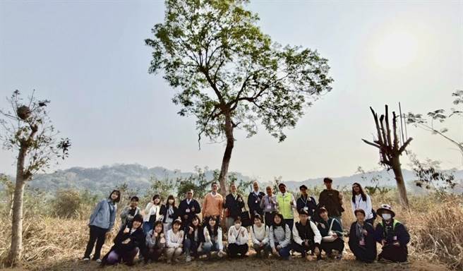 台湾、日本两所大学师生，在竹山镇木屐寮桃芝韧性树前合影。（南投县消防局提供／廖志晃南投传真）