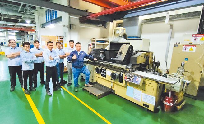 健椿工业董事长叶展硕（右一）和同仁们，在健椿创立之初所购买的第一台磨床前合影，传承意味浓厚，代表健椿从以往优良传统中迈开大步，开创世代新局。图／业者提供