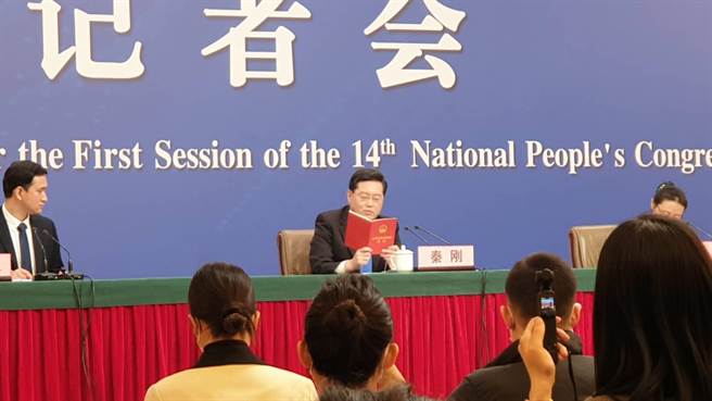 大陆外交部长秦刚（中）7日出席外长记者会，手持一本大陆宪法回应台湾问题。（蓝孝威摄）